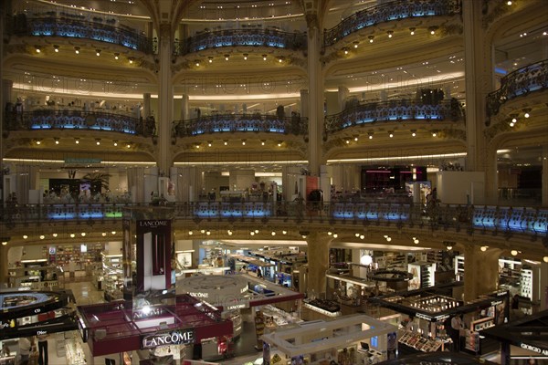 FRANCE, Ile de France, Paris, Opera Quarter. The central circular area under the glass dome of the Art Nouveau department store Galleries Lafayette showing the balconies and the perfume department on the ground floor