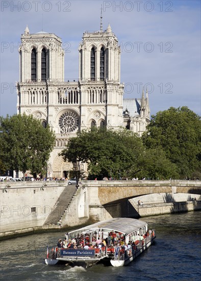 FRANCE, Ile de France, Paris, A bateaux mouches vedette pleasure boat on the River Seine taking sightseers past Notre Dame Cathedral on the Ile de la Cite