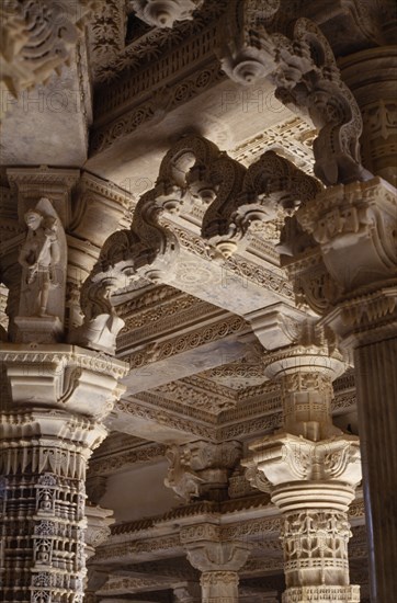 INDIA, Rajasthan, Mount Abu, Dilwara Temple complex dating from 11th-13th century A.D.  Detail of intricately carved and ornamented white marble ceiling and pillars.