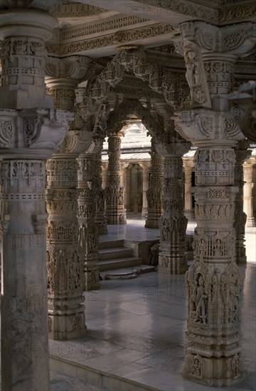 INDIA, Rajasthan, Mount Abu, Dilwara Temple complex dating from 11th-13th century A.D.  Detail of intricately carved and ornamented white marble ceiling and supporting pillars.