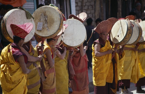 INDIA, Ladakh, Music, Tibetan Buddhist lamas in ceremonial dress playing traditional drums supported on poles at the commencement of a festival.