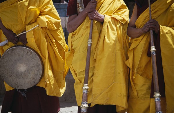 INDIA, Ladakh, Hemis Gompa, Tibetan Buddhist lamas in ceremonial yellow dress with traditional instruments attending annual Hemis Festival to celebrate birth of the founder of Tibetan Buddhism.