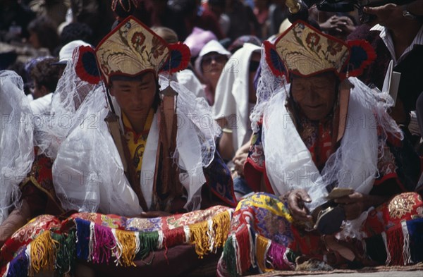 INDIA, Ladakh, Hemis Gompa, "Lamas wearing kartas receiving offerings from pilgrims during Hemis Festival to celebrate the birth of Guru Padmasambhava, founder of Tibetan Buddhism."