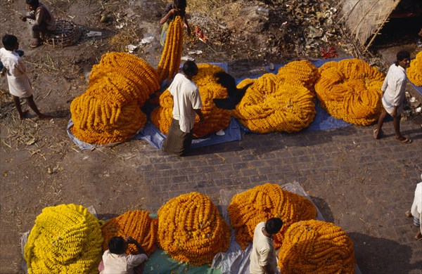 INDIA, West Bengal, Calcutta, "Looking down on marigold sellers.  Marigolds are sold by weight or in garlands and are used for weddings, funerals, puja and decoration. "