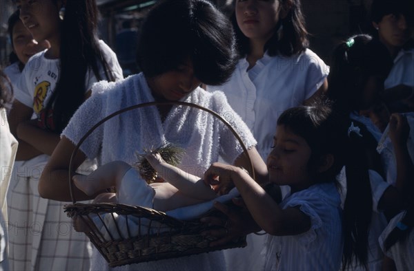 MEXICO, Mexico State, Chalma, Girls dressed in white and carrying lifesize infant figure during pilgrimage to church.