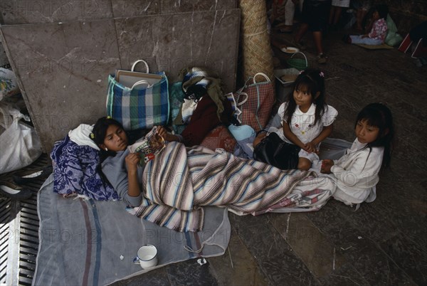 MEXICO, Mexico State, Chalma, Young woman and children on pilgrimage to Chalma resting on roadside surrounded by belongings.