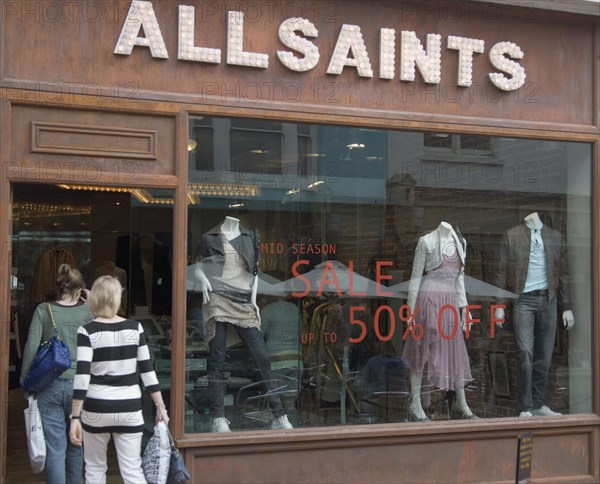 ENGLAND, East Sussex, Brighton, Shoppers entering the All Saints shop in Dukes street. 50% sale written on the window.