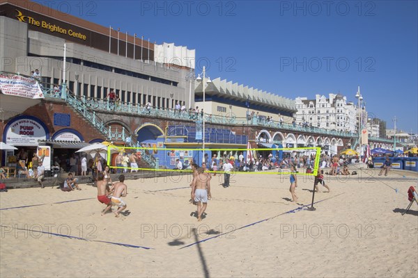 ENGLAND, East Sussex, Brighton, People playing beach volleybal on the sands in front of the Brighton Centre.