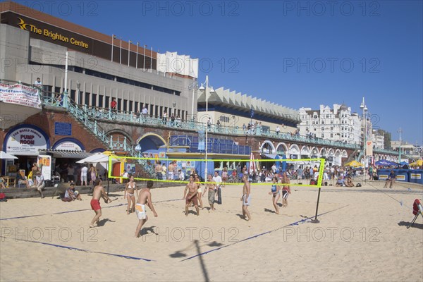 ENGLAND, East Sussex, Brighton, People playing beach volleybal on the sands in front of the Brighton Centre.