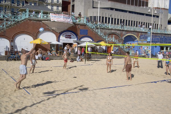 ENGLAND, East Sussex, Brighton, People playing beach volleybal on the sands in front of the Brighton Centre.