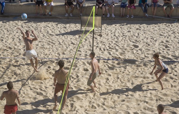 ENGLAND, East Sussex, Brighton, Beach volleyball game on the sands in front of the Grand Hotel.