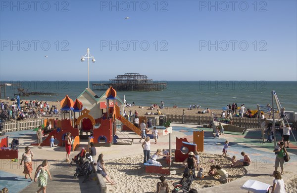 ENGLAND, East Sussex, Brighton, Childrens play area with the ruins of the West Pier behind.