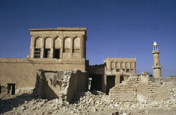 QATAR, Wakrah, Old village houses being demolished with a minaret of a mosque beyond