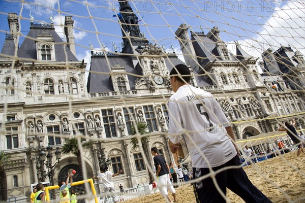 FRANCE, Ile de France, Paris, The Paris Plage urban beach. Boy wearing a Zidane football shirt playing in goal during a beach soccer childrens match in front of the Hotel de Ville Town Hall