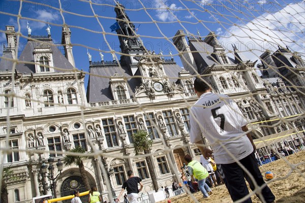 FRANCE, Ile de France, Paris, The Paris Plage urban beach. Boy wearing a Zidane football shirt playing in goal during a beach soccer childrens match in front of the Hotel de Ville Town Hall