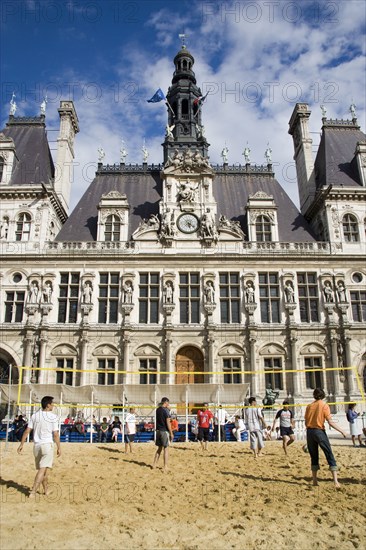 FRANCE, Ile de France, Paris, The Paris Plage urban beach. Young people playing beach volleyball in front of the Hotel de Ville Town Hall