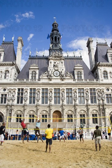 FRANCE, Ile de France, Paris, The Paris Plage urban beach. Young people playing beach volleyball in front of the Hotel de Ville Town Hall