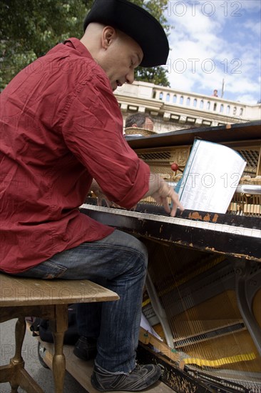 FRANCE, Ile de France, Paris, The Paris Plage urban beach. A singer playing a piano to an audience under the Pont Notre Dame on the Voie Georges Pompidou a usually busy road closed to traffic