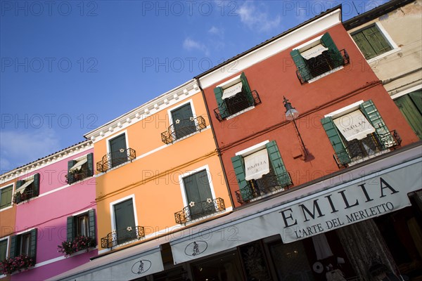 ITALY, Veneto, Venice, "Brightly coloured houses above lace shops on the lagoon island of Burano, historically the centre of the lace making industry in the region"