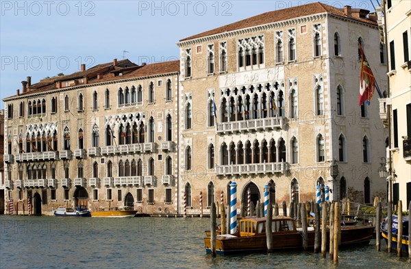 ITALY, Veneto, Venice, The palace of Ca' Foscari on the Grand Canal built for Doge Francesco Foscari in 1437. Now part of the University of Venice. Water taxis moored at wooden posts outside Palazzo Balbi the seat if the regional government