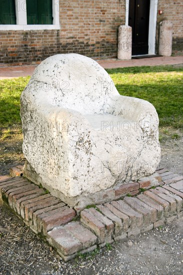 ITALY, Veneto, Venice, A marble seat said to be used as a throne by the 5th Century king Attila on the deserted lagoon island of Torcello