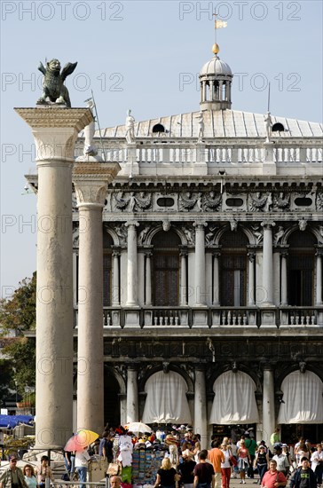 ITALY, Veneto, Venice, Tourists walk in the Piazetta below the winged Lion of Saint Mark on the Column San Marco and the Column of San Teodoro