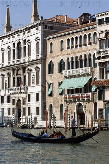 ITALY, Veneto, Venice, A gondola carrying tourists passes the Palazzo Papadopoli (on the left) on the Grand Canal