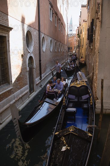 ITALY, Veneto, Venice, Gondolas carrying tourists along the narrow Rio di San Salvadore in the San Marco district with the Campanile in the distance