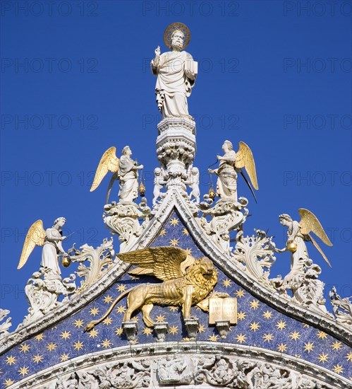 ITALY, Veneto, Venice, "The 15th Century statues of St Mark and Angels over the central arch of St Marks Basilica. The winged Lion of St Mark, the symbol of Venice, stands below the saint"