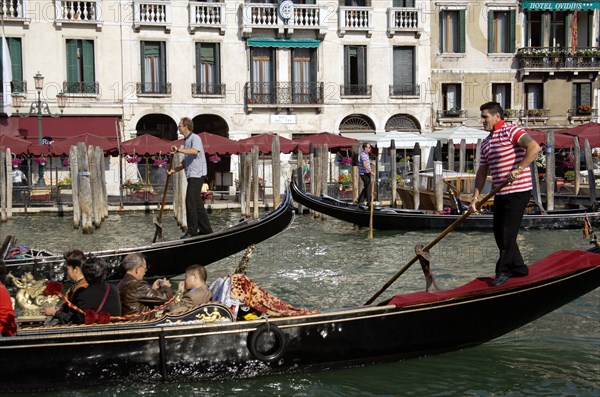 ITALY, Veneto, Venice, Gondoliers taking tourists on gondola rides on the Grand Canal