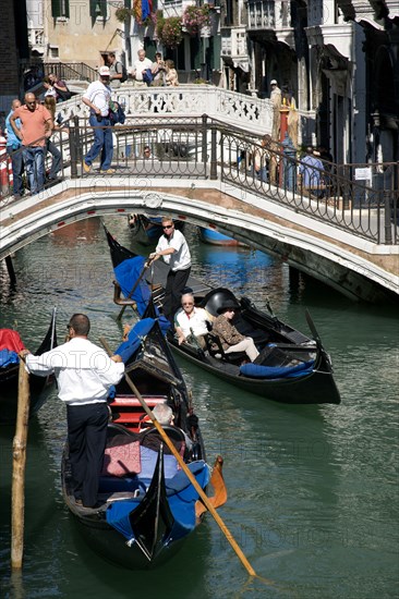 ITALY, Veneto, Venice, Gondolas with tourists passing along the Rio del Palazzo canal with its many small pedestrian bridges