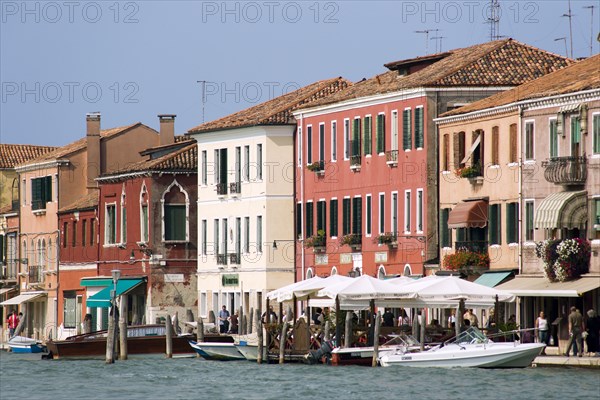 ITALY, Veneto, Venice, Boats on the Canale Grande di Murano moored beside restuarants on the Fondamenta Cavour busy with tourists sightseeing
