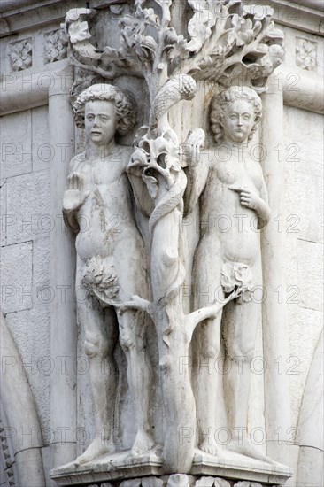 ITALY, Veneto, Venice, A stone carving of Adam and Eve with the Serpent in the tree on the corner of the Doges Palace by the Piazzetta