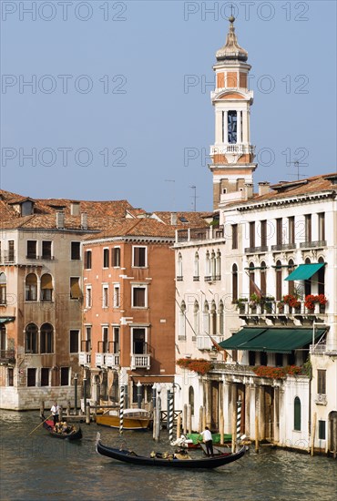 ITALY, Veneto, Venice, Gondolas with sightseeing tourists on the Grand Canal with the bell tower of the chursh of Santi Apostoli behind palazzos lining the canal