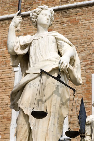 ITALY, Veneto, Venice, A female statue holding the scales of justice standing outside the entrance to the Arsenal