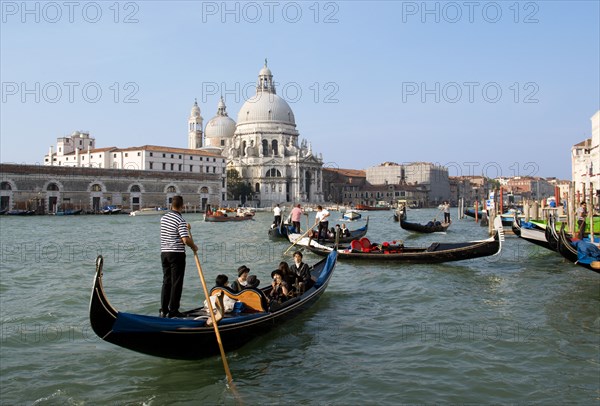 ITALY, Veneto, Venice, Gondolas with sightseeing tourists on the Grand Canal in front of the Baroque church of Santa Maria della Salute