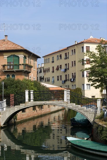 ITALY, Veneto, Venice, Housing beside a bridge crossing a canal with moored boats on the Lido