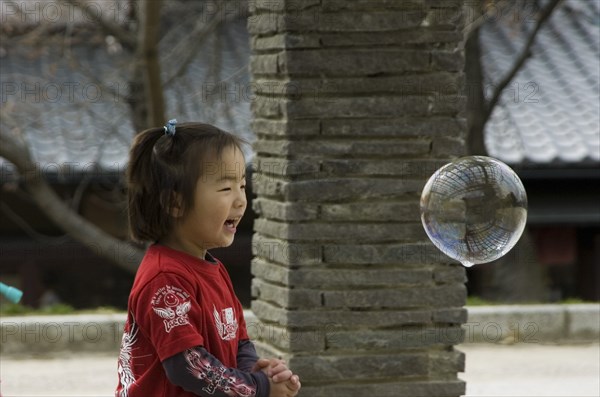 JAPAN, Honshu, Kyoto, Child playing with bubbles near Maruyama-koen Park