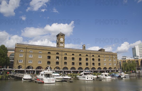 ENGLAND, London, St Catherine’s Dock with yachts moored next to the former warehouses which are now luxury apartments.