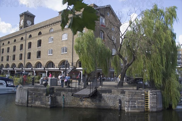 ENGLAND, London, St Catherines dock former warehouses now luxury  apartments. Extending foobridge withdrawn to although boats through the lock.