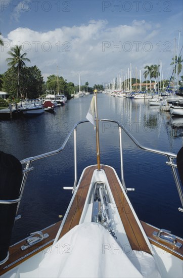 USA, Florida, Fort Lauderdale, View of Canal from boats bow with yachts moored outside waterfront houses along waterway