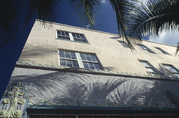 USA, Florida, Miami , South Beach. Detail of Art Deco building. Angled view with palm trees creating shadows on exterior.