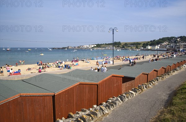 ENGLAND, Dorset, Swanage Bay, View across beach hut roofs towards sandy stretch of beach and sea