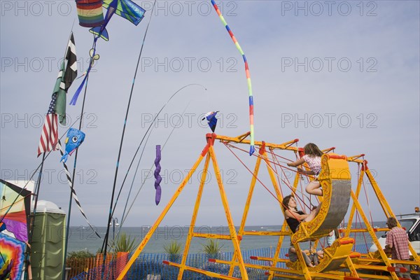 ENGLAND, Dorset, Swanage Bay, Girls on amusment ride overlooking the sea