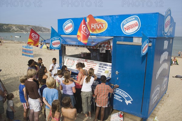 ENGLAND, Dorset, Swanage Bay, A group of children queuing at Ice Cream stall