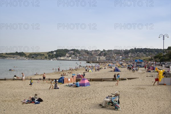ENGLAND, Dorset, Swanage Bay, View along sandy beach with sunbathers on the sand