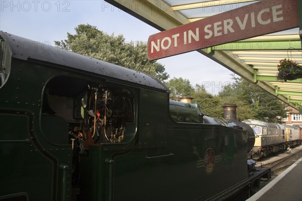 ENGLAND, Dorset, Swanage, Steam Railway Station. Train waiting in station with a Not in Service sign hanging from covered platform