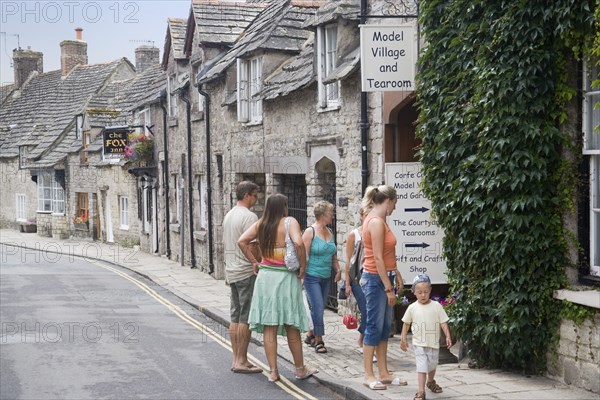 ENGLAND, Dorset, Corfe, Visitors outside a Model Village and Tearoom shop in a row of traditional cottages