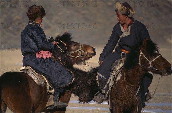 MONGOLIA, Bayan Olgi Province, Nomads, Kazakh nomads playing Bozkashi at Kazakh New Year festival.  Two riders holding headless animal carcass between them.