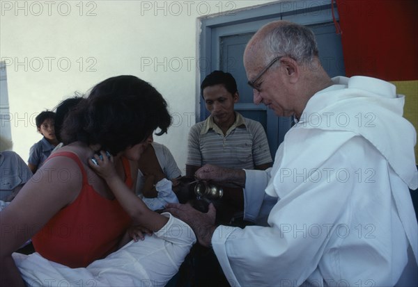 RELIGION, Baptism, Christening, "Priest pouring holy water over infants head, La Forestal, Bolivia."